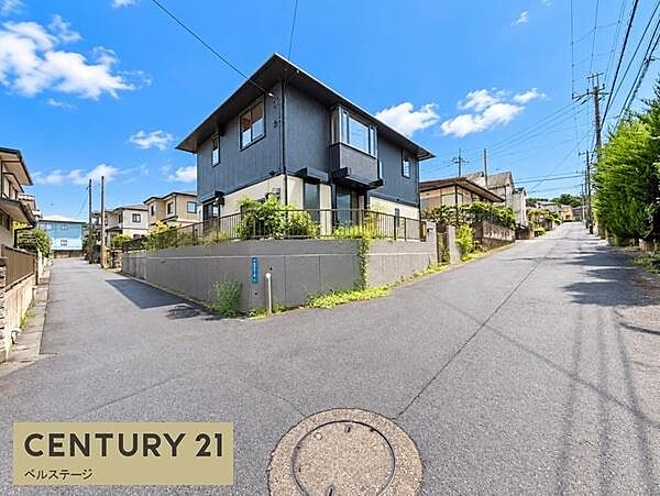 建物前には見通しの良い道路が広がり、周辺の街並みまで確認できる立地です。道路幅や接道の様子も写真で確認でき、実際の暮らしをイメージしやすい現地写真です。