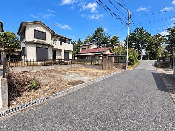 前面道路との接道状況が分かりやすい外観写真です。敷地前面にはゆとりがあり、駐車スペースとして活用しやすいほか、植栽を取り入れた庭づくりなども楽しめる住環境です。