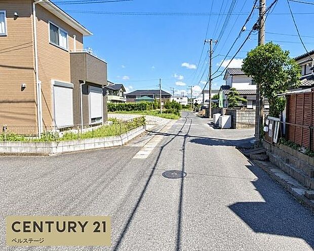 周囲には戸建住宅が建ち並ぶ落ち着いた住宅街。道路は見通しがよく、沿道には植栽や庭のある住宅も多く、穏やかな街並みが広がっています。