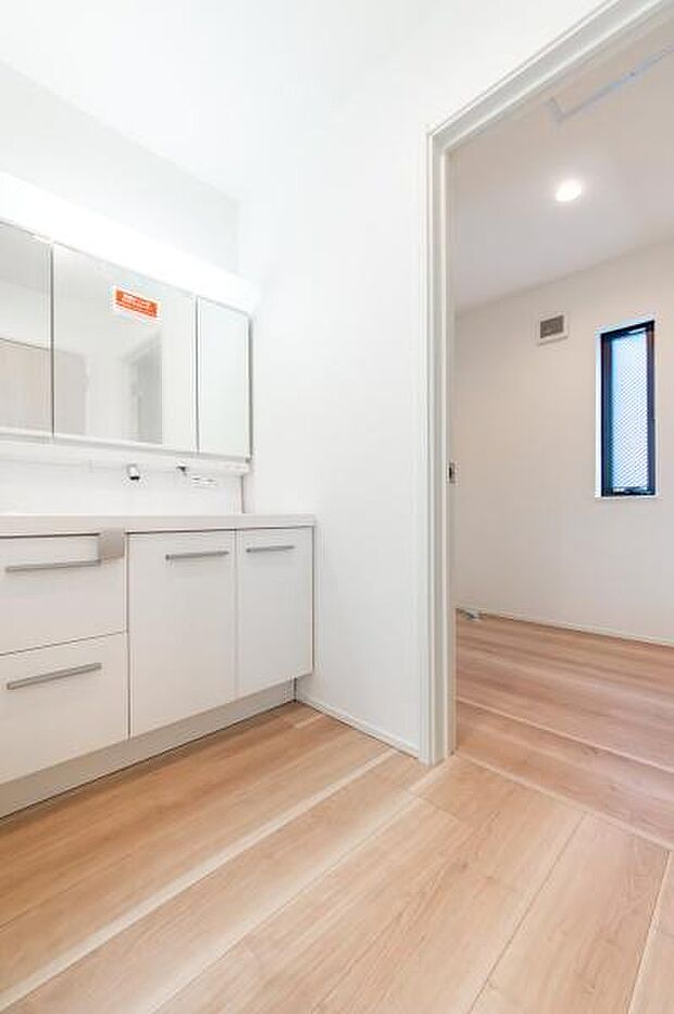 清潔感あふれる真っ白な洗面室。横のゆったりスペースは洗濯機を置いても余裕たっぷり。忙しい朝も家族みんなでスムーズに身支度が整います。