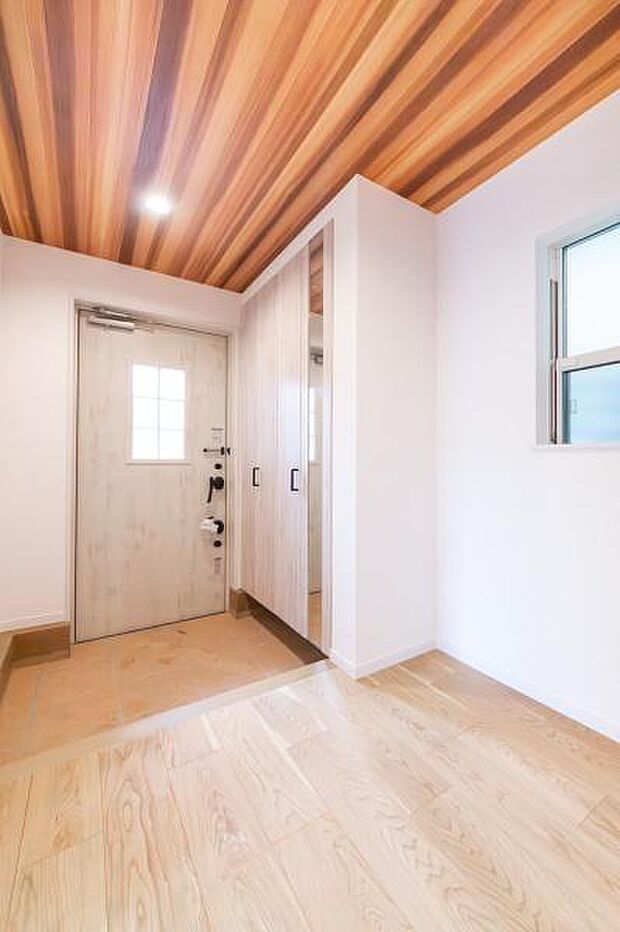 モダンなデザインが目を引く玄関。天然木の風合いで、訪れる人を温かく迎え入れます。