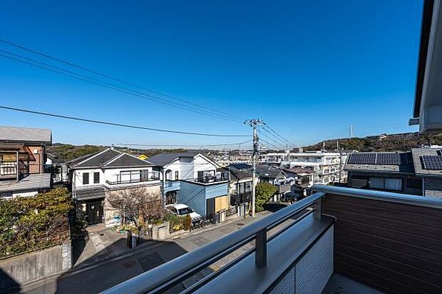 青空が広がる開放的なバルコニーからの眺望。周囲に高い建物が少なく、日当たりと風通しが良好です。