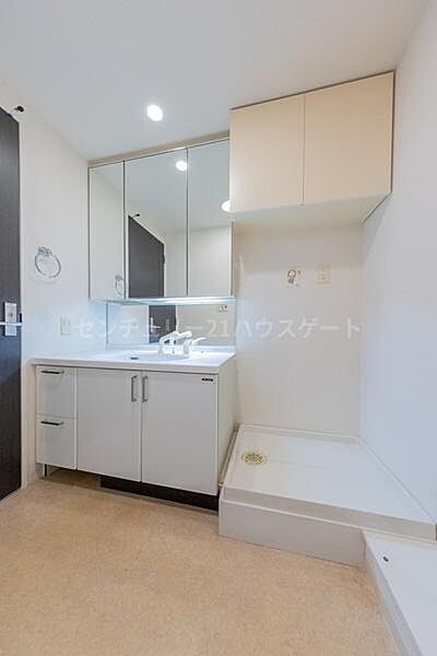 身支度がスムーズに整う三面鏡付きの洗面化粧台。洗濯機置場の上部には吊り戸棚もあり、洗剤やタオルなどの収納にも困りません。