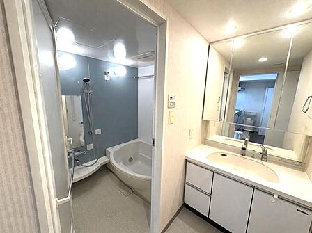 白を基調とした清潔感あふれる洗面脱衣室。三面鏡付きの洗面台は収納豊富です。