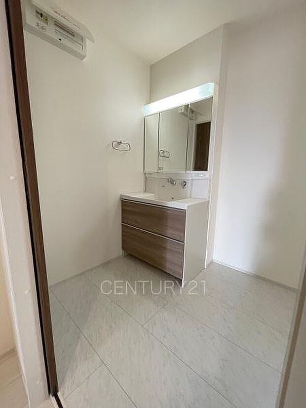 三面鏡付きの洗面台には鏡の裏に収納があり、すっきり片付けられます。洗髪も可能な伸縮機能つきシャワーヘッドです。