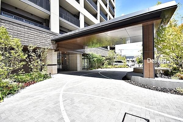 【エントランス】車寄せや来客用駐車場を備えた、美しく管理された迎賓空間。専用シャトルカー運行で駅へのアクセスも快適です。優雅で便利な暮らしの始まりを予感させます。