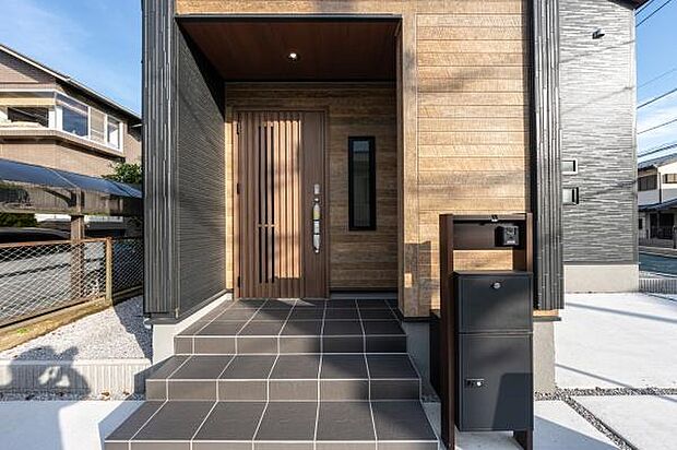 モダンなデザインが目を引く玄関。天然木の風合いで、訪れる人を温かく迎え入れます。