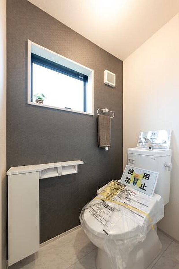 お洒落な壁紙でコーディネートされたお手洗い。収納カウンター付きで、機能性も兼ね備えています。