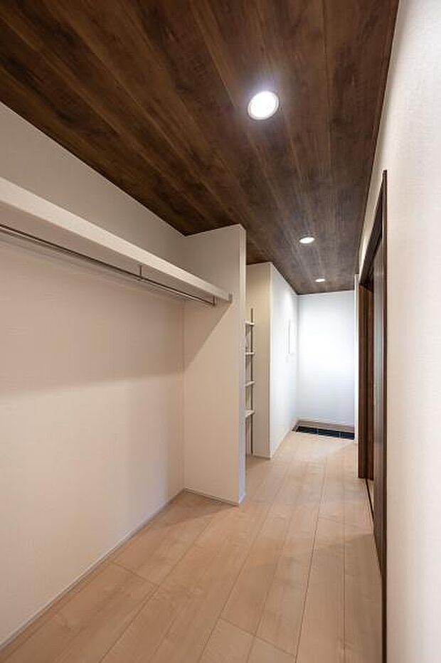 お洒落な木目天井が続く玄関収納。棚板とハンガーパイプ付きで、整理整頓しやすい。