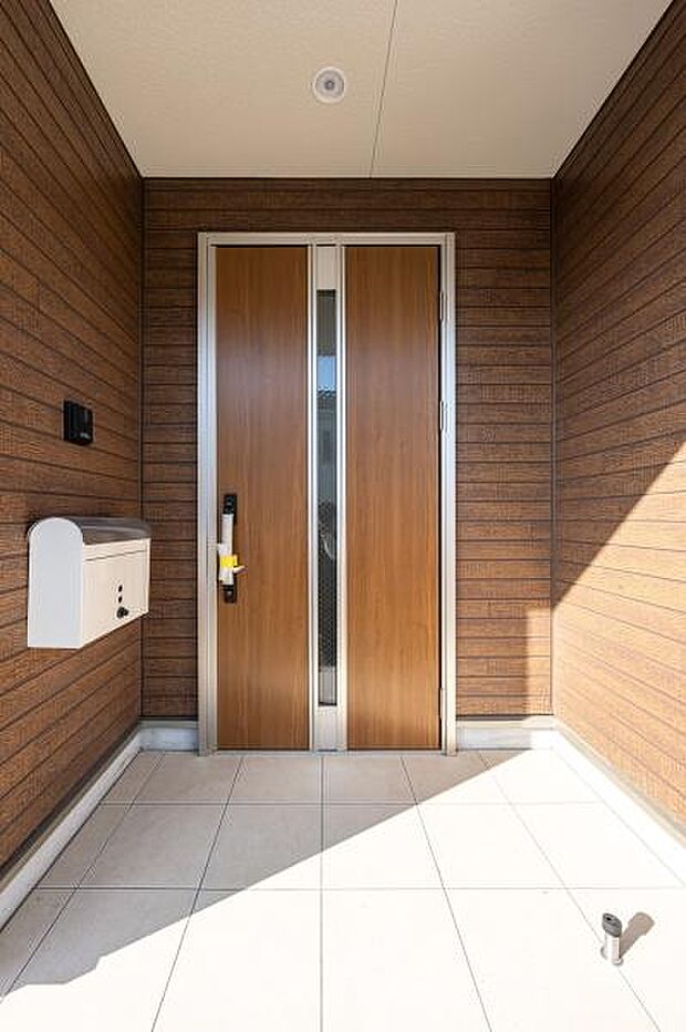 我が家の『顔』となる、洗練されたエントランス。温かい木目の扉が、あなたを優しく迎え入れます。