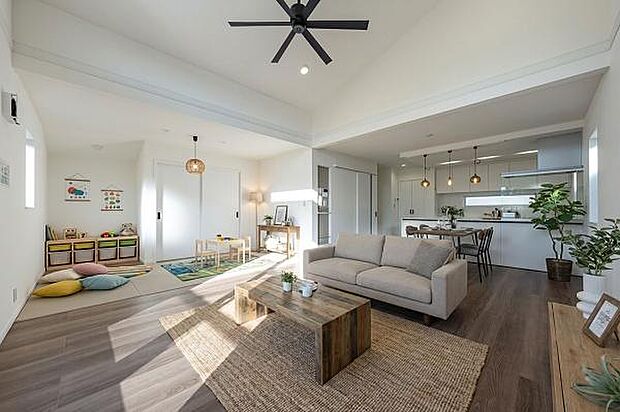 勾配天井とシーリングファンが演出する開放的なLDK。お子様の遊び場や休息に便利なタタミコーナーが隣接しています。（本画像はCGにて家具等を配置しております。実際に家具等はおかれておりません。）