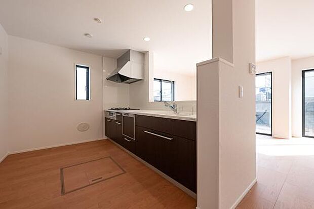 落ち着いた木目調のデザインが美しいシステムキッチン。床下収納や広い作業スペースなど、家事効率を高める工夫が満載です。