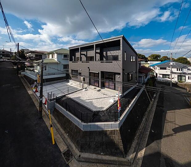 高台の角地という開放的なロケーション。黒を基調としたスタイリッシュな外観が、街並みに洗練された存在感を放ちます。