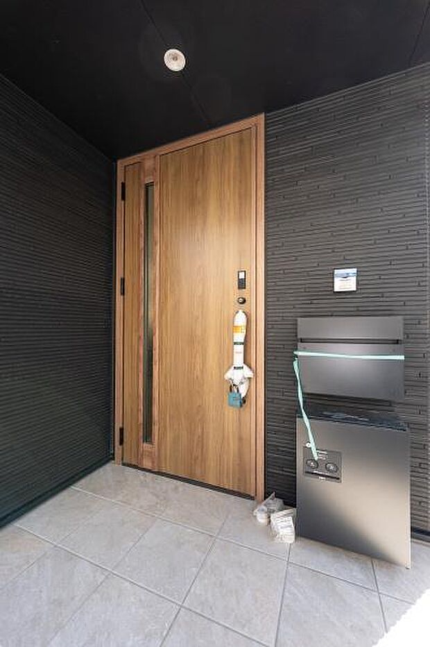 邸宅の顔にふさわしい重厚感ある玄関扉。落ち着いた色調の外壁と木目調のドアが調和し、訪れる人を優雅に迎え入れます。