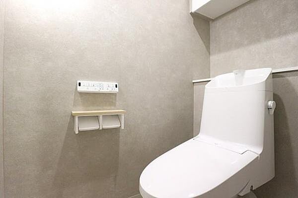【トイレ】温水洗浄機能付きのトイレ。背面にはカウンターがあり、トイレ用品の収納や小物を飾るスペースとしても活用できます。