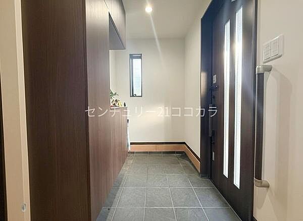 玄関重厚感あるドアと落ち着いたタイル床が迎えてくれる玄関アプローチ。手すりが設置されており、靴の脱ぎ履きも安心・スムーズです。室内の写真はCGで家具を消して空室後のイメージを再現しています。