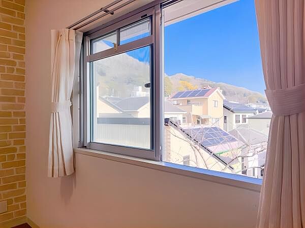 【東側 洋室からの眺望】朝日が差し込む東側の窓。山並みが見え、自然を近くに感じられます。