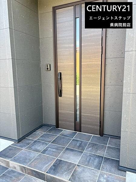 落ち着いた色合いのタイルと木目調のドアが調和した玄関です。シンプルなデザインが印象的で全体的にモダンな雰囲気も魅力です。段差が低めに設計されているので出入りもスムーズに行えます。