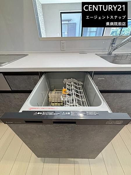 食洗機が備わったキッチンとなっております。シンプルで使いやすい設計が特徴です。ゆとりのある作業スペースも確保されています。キッチンの収納も充実しています。窓があり明るさも感じられる空間です。