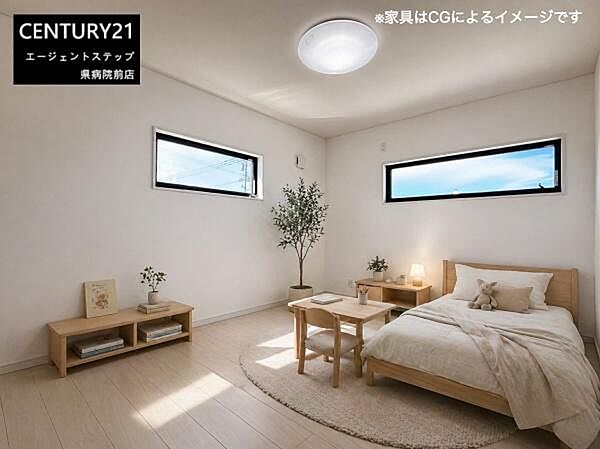 洋室はシンプルなデザインで開放的な窓が光をたっぷり取り入れます。床や家具の色合いが落ち着いた雰囲気を演出しています。観葉植物やアクセント小物の配置もバランスよく清潔感ある空間です。