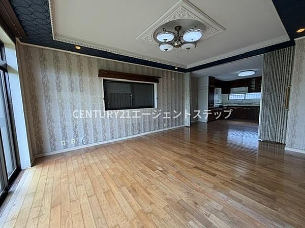 広々としたリビング空間が魅力です。天井のデザインや照明が印象的で上質な雰囲気を演出しています。窓から十分な明るさが入り開放感も感じられます。フローリングがきれいに保たれています。