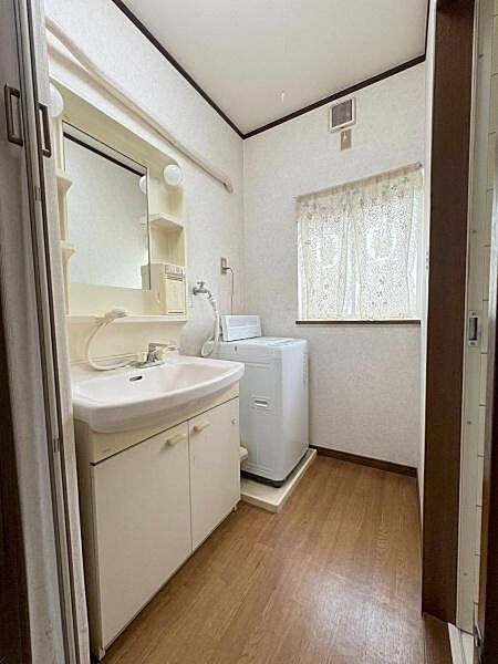 【洗面台・洗面所】洗面台と洗濯機置き場が並ぶ洗面脱衣室。※ＡＩを使用し編集した画像です。細部設備については一部描写が不足している箇所がございますので、あらかじめご了承ください。