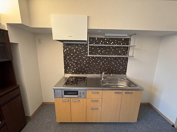 【キッチン】収納×ガスコンロ3口付のシステムキッチン※AI加工により荷物など除去加工しています。実際の状況と異なる場合があります。