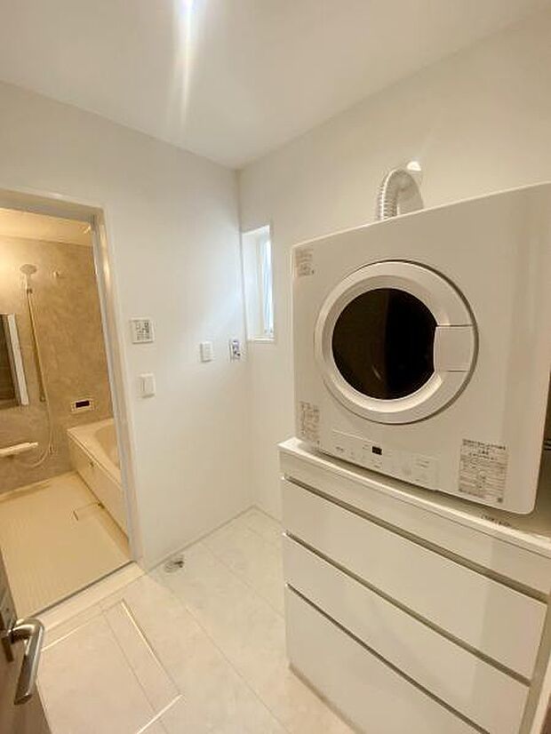 乾燥機や収納棚が備え付けの洗面所です。