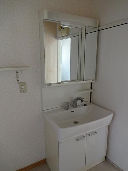 【洗面室】シンプルな洗面化粧台　隣は洗濯機スペース。棚がついています。