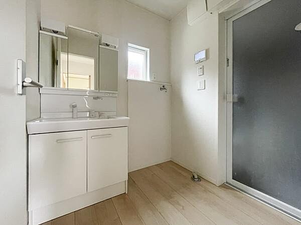 白を基調とした洗面台は三面鏡で使い勝手が良いです。採光窓があり明るさも確保されています。収納スペースも確保されていて整理整頓に便利です。広々とした洗面所でゆとりを感じられます。