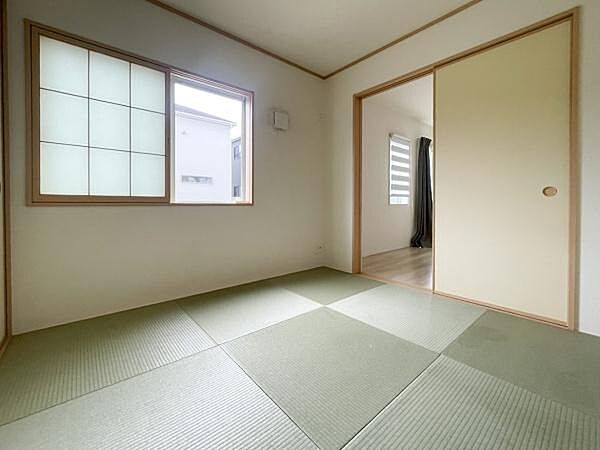 リビング横に併設された、1階約4.5帖の和室です。窓からの自然光がしっかりと入り、畳が広がる落ち着いた空間となっています。収納もあり、使い勝手の良さも魅力です。