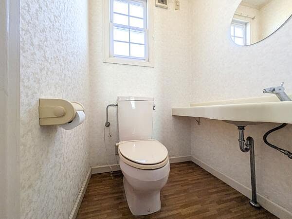 窓付きで明るいトイレ空間です。手洗いスペースが広く使い勝手の良い設計です。壁や床がシンプルなデザインで清潔感があります。設備が整っており快適に利用できます。