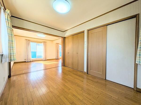 明るい光が差し込む洋室です。二面採光で室内が広く感じられます。ナチュラルなフローリングが落ち着いた雰囲気を演出しています。窓が多く換気もしやすい設計です。
