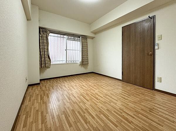 窓から光が入りやすい洋室です。木目調のフローリングが落ち着いた雰囲気を演出します。シンプルなデザインで家具も配置しやすい空間です。壁や天井も明るい色合いで圧迫感を感じにくい設計です。