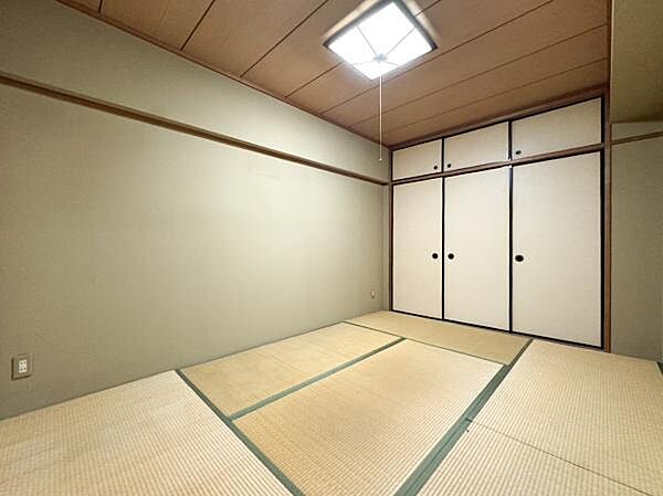 落ち着いた雰囲気の和室です。シンプルなデザインで整った畳が印象的です。収納スペースとして便利な押し入れも備わっています。照明が部屋全体を明るく照らしています。