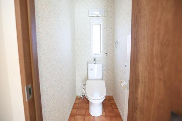 窓が付いており採光を確保しやすいトイレです。シンプルな内装で清潔感を感じられます。扉を開けてすぐにアクセスできるレイアウトとなっています。タイル調の床がアクセントになっています。
