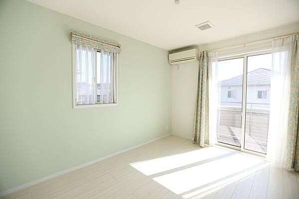 大きな窓からたっぷり光が差し込む洋室です。明るい壁色と床が調和し部屋全体を開放的な印象にしています。エアコンも設置済みで快適な室内環境が保てます。窓が二面あるため風通しも良好です。
