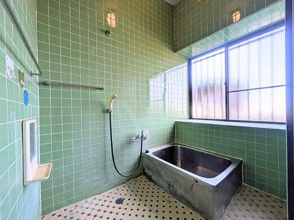 レトロな雰囲気が特徴のバスルームです。大きな窓からの採光もあり明るく開放的な空間です。タイル張りの壁面が清潔感を演出しています。浴槽や設備もシンプルでお手入れしやすいです。