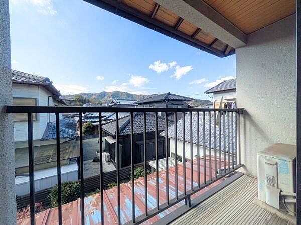 バルコニーからは開放感のある山並みが見渡せます。屋根付きで天候を気にせず活用できます。周囲の住宅街の雰囲気も感じられる眺望です。床面も使いやすい造りとなっています。
