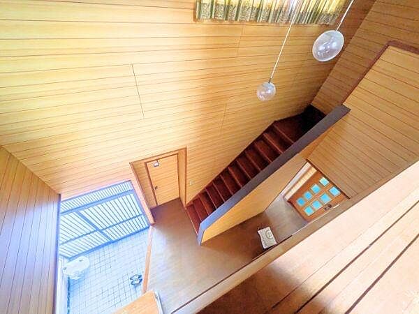 玄関から階段そして各部屋へのアプローチが直線的に配置されています。天井のペンダントライトが空間にアクセントを与えており明るさを確保しやすいです。木目調の内装が特徴的で全体として統一感があります。