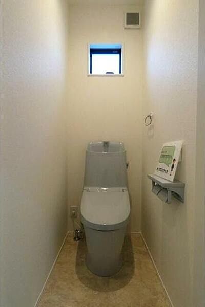 清潔感のあるトイレ空間です。小窓が設けられており換気もしやすくなっています。床や壁もシンプルなデザインでどなたにも使いやすい仕様です。ペーパーホルダーもあり使い勝手に配慮されています。