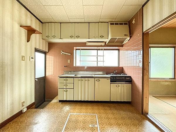 大きな窓から自然光が差し込むキッチンです。吊戸棚や収納スペースも豊富に備えています。隣接する和室との動線が便利です。換気扇やガスコンロ付きで日々の料理をサポートします。