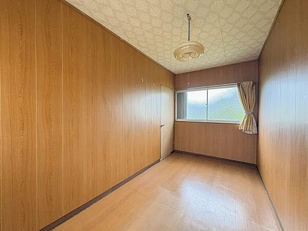 壁と床が木目調でまとまった洋室です。シンプルなデザインでインテリアのレイアウトも自由自在です。天井には照明が設置されており使い勝手の良い空間となっています。
