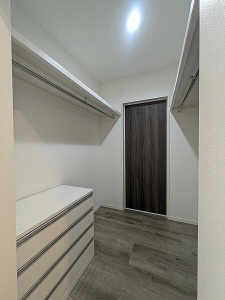 シンプルなデザインですっきりとした収納空間です。ハンガーポールと引き出しが備わっており用途に合わせて収納が可能です。床や扉の色合いが落ち着いており全体的に統一感があります。