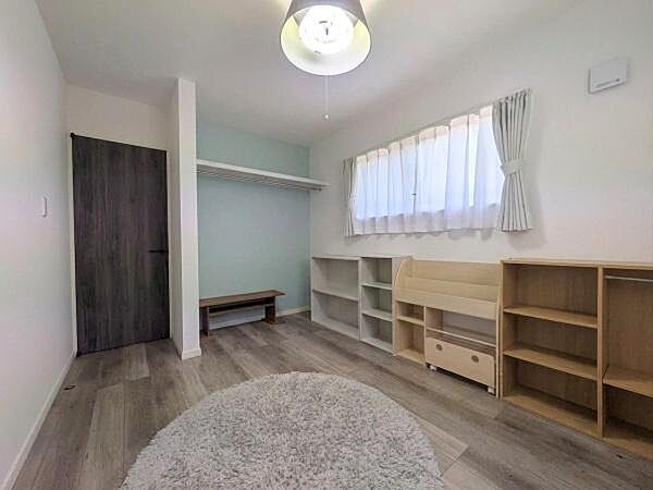 明るい窓から自然光がたっぷり入る洋室です。落ち着いた色合いの床と壁が空間に調和をもたらします。シンプルなデザインで幅広い用途に対応します。