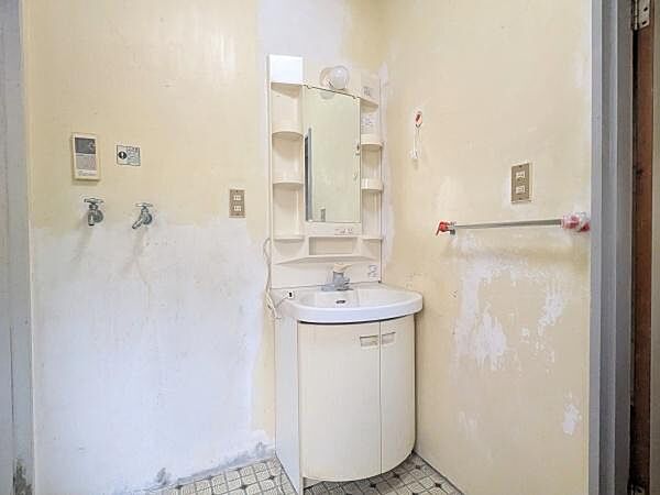 洗面台はシンプルなデザインで収納棚が付いており小物整理にも便利です。鏡も大きく身だしなみのチェックがしやすい仕様です。水栓やコンセントも備わっており日常使用に対応しています。