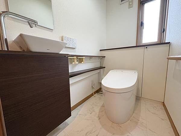 明るさを感じるトイレ空間です。独立した手洗いスペースが設けられています。窓付きで換気もしやすい設計になっています。収納スペースも備わっており使い勝手のよい仕様です。