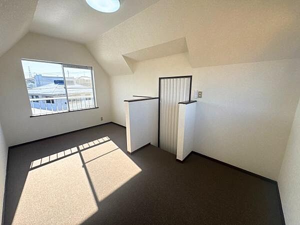 大きな窓からたっぷりと光が入る洋室です。天井が高く開放感があります。白を基調とした壁で明るい印象です。シンプルな空間で使いやすいレイアウトになっています。