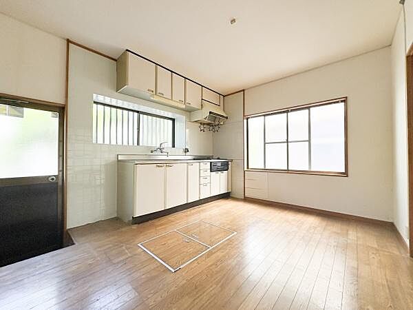 窓から光が差し込む明るいキッチンです。十分なスペースがあり使いやすさが感じられます。収納もしっかり確保されています。