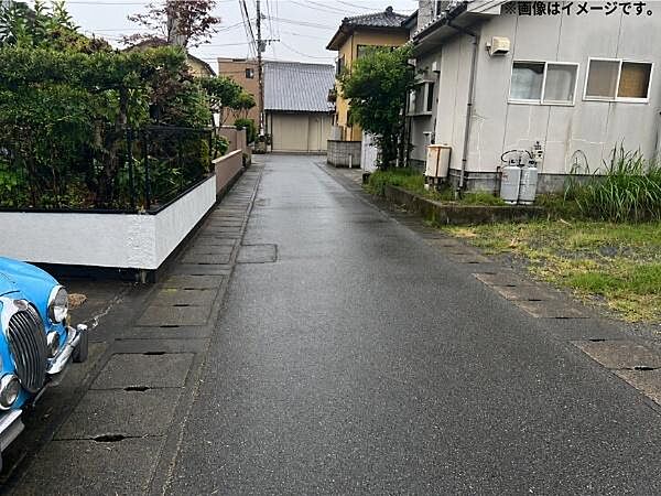 静かな住宅街に位置し周囲には緑も感じられる現地土地写真です。前面道路も整備されており車の出入りも安心です。周辺には戸建てが並び落ち着いた雰囲気が漂っています。